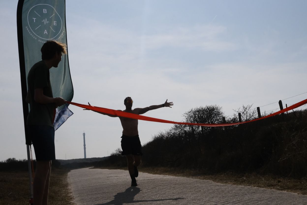 Hardlopers onder de finishboog in het Amsterdamse Bos
